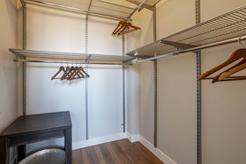 a spacious walk in closet with a desk and hangers